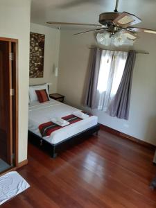 a bedroom with a bed and a ceiling fan at Liam's Guesthouse Adults Only in Chiang Mai