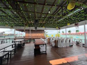 ein Restaurant mit Tischen und Stühlen und Blick auf das Wasser in der Unterkunft Derawan Fisheries Cottage in Derawan Islands
