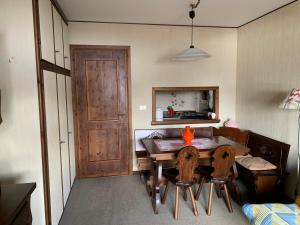 a dining room with a table and chairs and a door at Monolocale con terrazzo e vista spettacolare sui monti in Sestriere