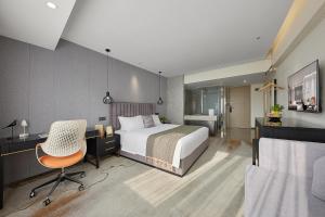 a bedroom with a bed and a desk and a chair at Dashen Hotel Shunde Lecong in Shunde