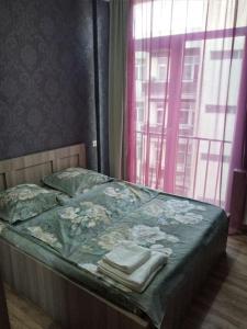 uma cama com toalhas num quarto com uma janela em Marine's flat em Tbilisi