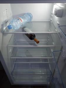uma garrafa de água num frigorífico vazio em Marine's flat em Tbilisi