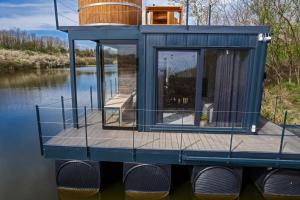 a tiny house on a dock on a body of water at no. 1 in Kulpin