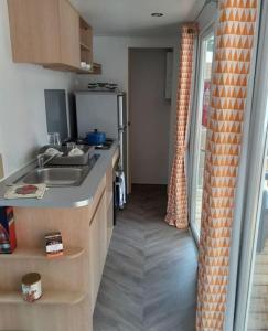a kitchen with a sink and a counter top at Mobilhome 4 pers La palmyre in Les Mathes