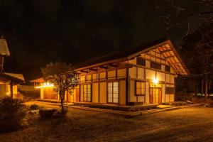 una casa por la noche con las luces encendidas en 響きの宿, en Sato-moriya