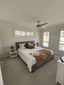 1 dormitorio con 1 cama grande y ventilador de techo en Worrigee Retreat Guesthouse, en Worragee