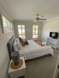 a bedroom with a large bed and a flat screen tv at Worrigee Retreat Guesthouse in Worragee