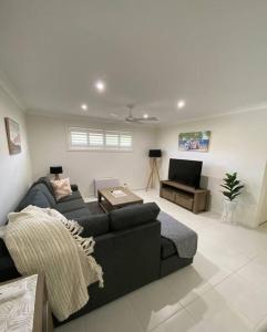 a living room with a couch and a television at Worrigee Retreat Guesthouse in Worragee