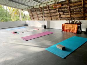 a room with three mats on the floor with a table at Tattwamasi Ayuryoga with Breakfast and Yoga in Varkala