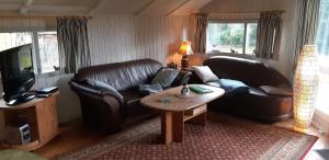 ein Wohnzimmer mit 2 Ledersofas und einem Couchtisch in der Unterkunft Ferienhaus Diedrichsen in Brekendorf