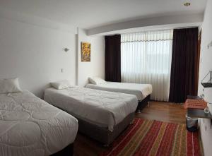 ein Hotelzimmer mit 2 Betten und einem Fenster in der Unterkunft APARTAMENTO RYG CUSCO in Cusco
