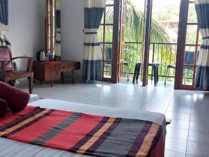 a bedroom with a bed and a view of a balcony at The Comfort in Kandy