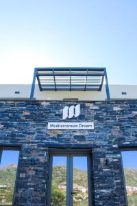 a brick building with a sign on top of it at Mediterranean Dream in Palaiochóra