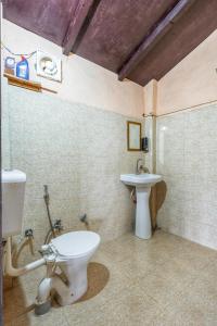 a bathroom with a toilet and a sink at Zenoaks Homestay in Almora