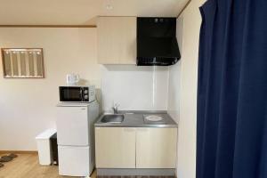 a small kitchen with a sink and a microwave at 富士山下Cottage-B in Narusawa