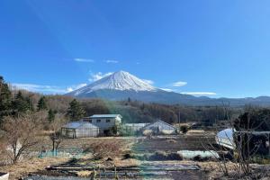 a snow covered mountain in the distance with houses and a mountain w obiekcie 富士山下Cottage-B w mieście Narusawa