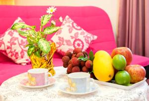 a table with fruit and cups on a pink couch at Free World B&B in Wujie
