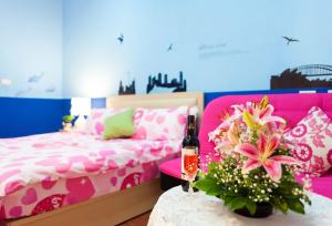 五結鄉的住宿－自由天地民宿，一间卧室配有粉色床和一张带一瓶葡萄酒的桌子。
