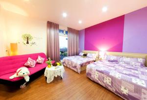 1 dormitorio con 2 camas y pared de color rosa en Free World B&B, en Wujie