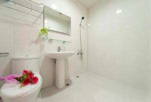 a white bathroom with a toilet and a sink at Free World B&B in Wujie