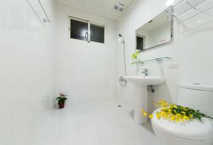 Un baño blanco con inodoro y lavabo. en Free World B&B, en Wujie