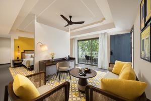 a living room with a couch and a table at The Yellow House, Goa - IHCL SeleQtions in Anjuna