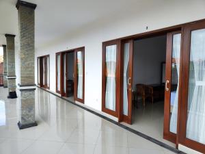 沙努爾的住宿－LA Homestay sanur，走廊设有滑动玻璃门和桌子
