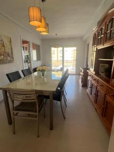 cocina y comedor con mesa y sillas en Apartamento junto a playa y cerca de campo de golf, en El Perellonet