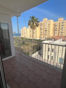 a balcony with a view of the ocean and buildings at Apartamento junto a playa y cerca de campo de golf in El Perellonet
