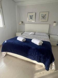 1 dormitorio con 1 cama grande y 2 toallas. en Apartamento junto a playa y cerca de campo de golf, en El Perellonet