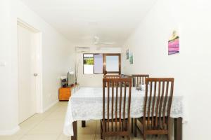 a dining room with a white table and chairs at Gardenia Apartment-02 in Nadi