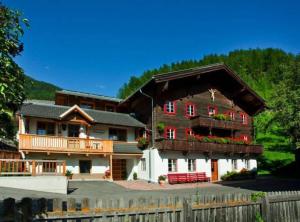 ein großes Haus mit einem Gameradach in der Unterkunft Appartements Birnbaumer in Matrei in Osttirol