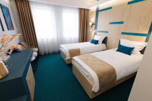 una camera d'albergo con 2 letti e una scrivania di Hotel YVY a Sebeş