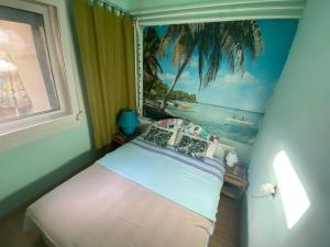 a bedroom with a bed with a picture of a beach at Grany's Retro Guesthouse near Budapest AirPort in Vecsés