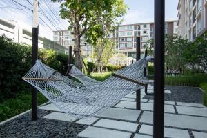 a hammock in a park with buildings in the background at First Choice Suites by the Sea SHA Plus Extra in Hua Hin