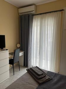 - une chambre avec un lit, un bureau et une fenêtre dans l'établissement Comfort apartment for small family, à Loutraki