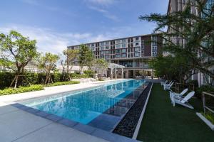 uma piscina em frente a um edifício em First Choice Suites by the Sea SHA Plus Extra em Hua Hin