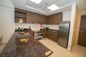a kitchen with a granite counter top and a refrigerator at ABIDOS HOLIDAY HOMES Windsor Residence in Dubai
