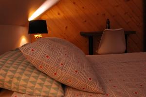 a bed with a pillow and a table in a room at Domek nad Solinką in Żubracze