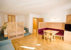 ein Wohnzimmer mit einem Tisch und ein Zimmer mit einem Bett in der Unterkunft Appartements Birnbaumer in Matrei in Osttirol