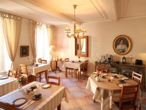 una sala da pranzo con tavoli, sedie e un dipinto di La Villa Garenne a Vannes