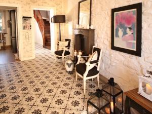 uma sala de estar com cadeiras, uma mesa e uma lareira em La Villa Garenne em Vannes