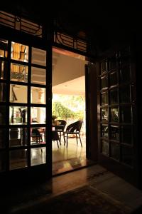Otwarte drzwi na patio ze stołem i krzesłami w obiekcie Villa Benares w mieście Waranasi