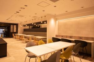 高知市にある高知サンライズホテルのテーブルと椅子が備わるレストラン