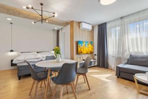 - un salon et une chambre avec une table et des chaises dans l'établissement LAM Concrete w AC & Balcony, à Bratislava