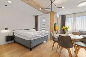 ブラチスラヴァにあるLAM Concrete w AC & Balconyのベッドルーム1室(ベッド1台、テーブル付)、ダイニングルームが備わります。