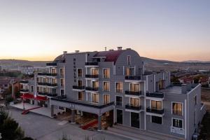 an aerial view of a building with a sunset in the background at Afyon Regulus Thermal Apart Hotel & Villas in Gazligol