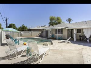 um quintal com cadeiras e uma piscina e uma casa em Scottsdale's Clubhouse Escape em Scottsdale