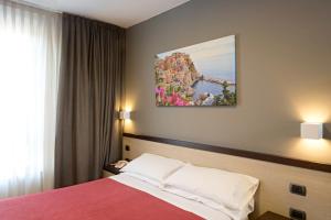 a hotel room with a bed and a painting on the wall at Hotel Spinelli in Viareggio