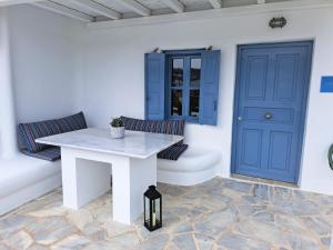 a white table and two chairs with a blue door at Ariadne Pool Studio at Ornos in Ornos